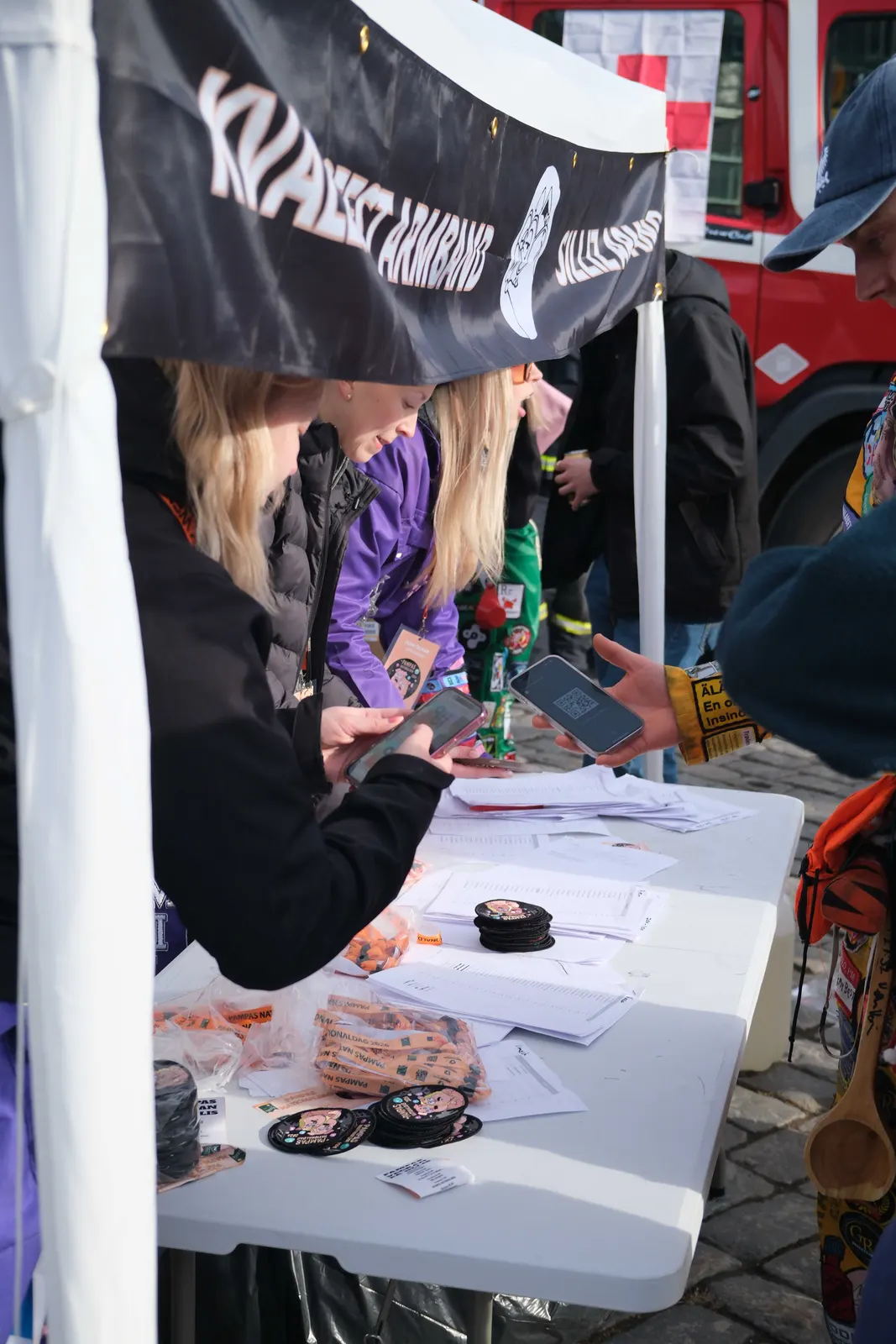 Organizers handing out wristbands at a ticket stand.